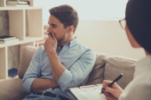 concerned man sitting in therapy