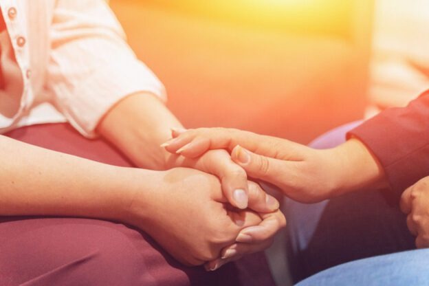 close up on two people with one putting their hand over the other's