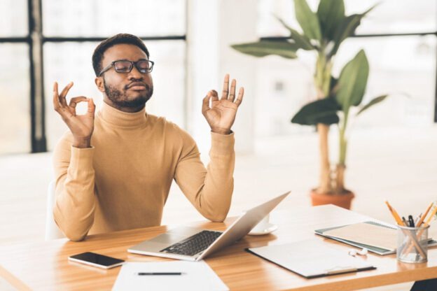 man sitting at desk taking a moment to relax