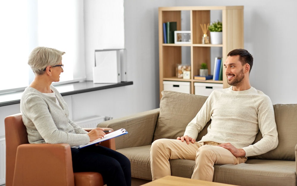 man smiling with therapist during individual therapy session