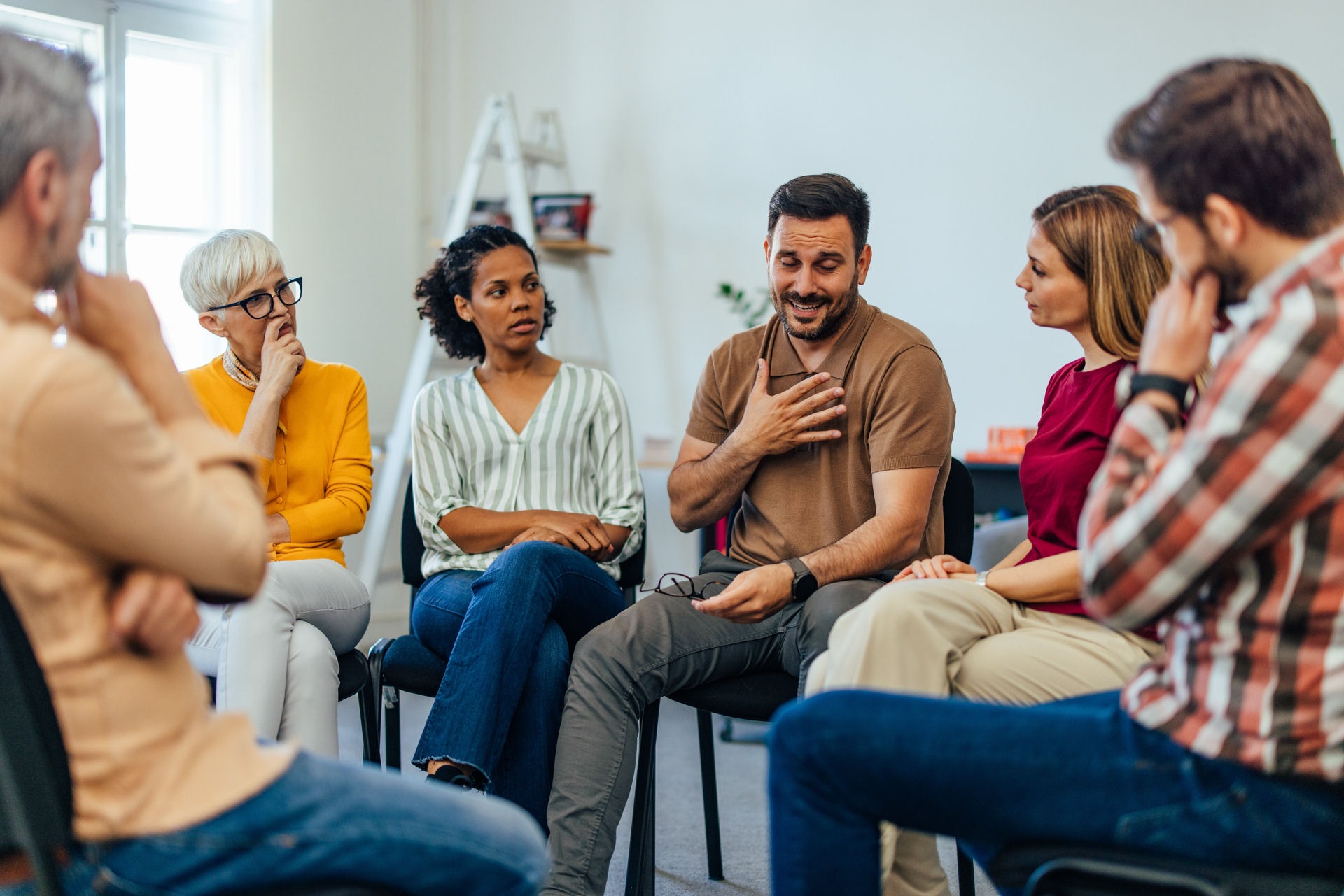 group therapy session where one man is sharing with the group