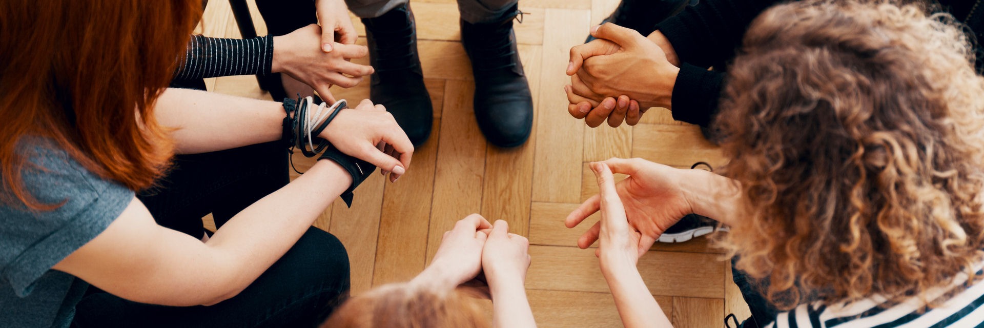 group's hands as they sit in a circle