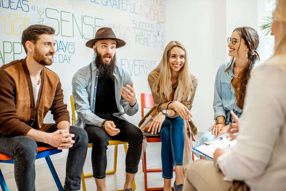 group of young adults sitting in group therapy