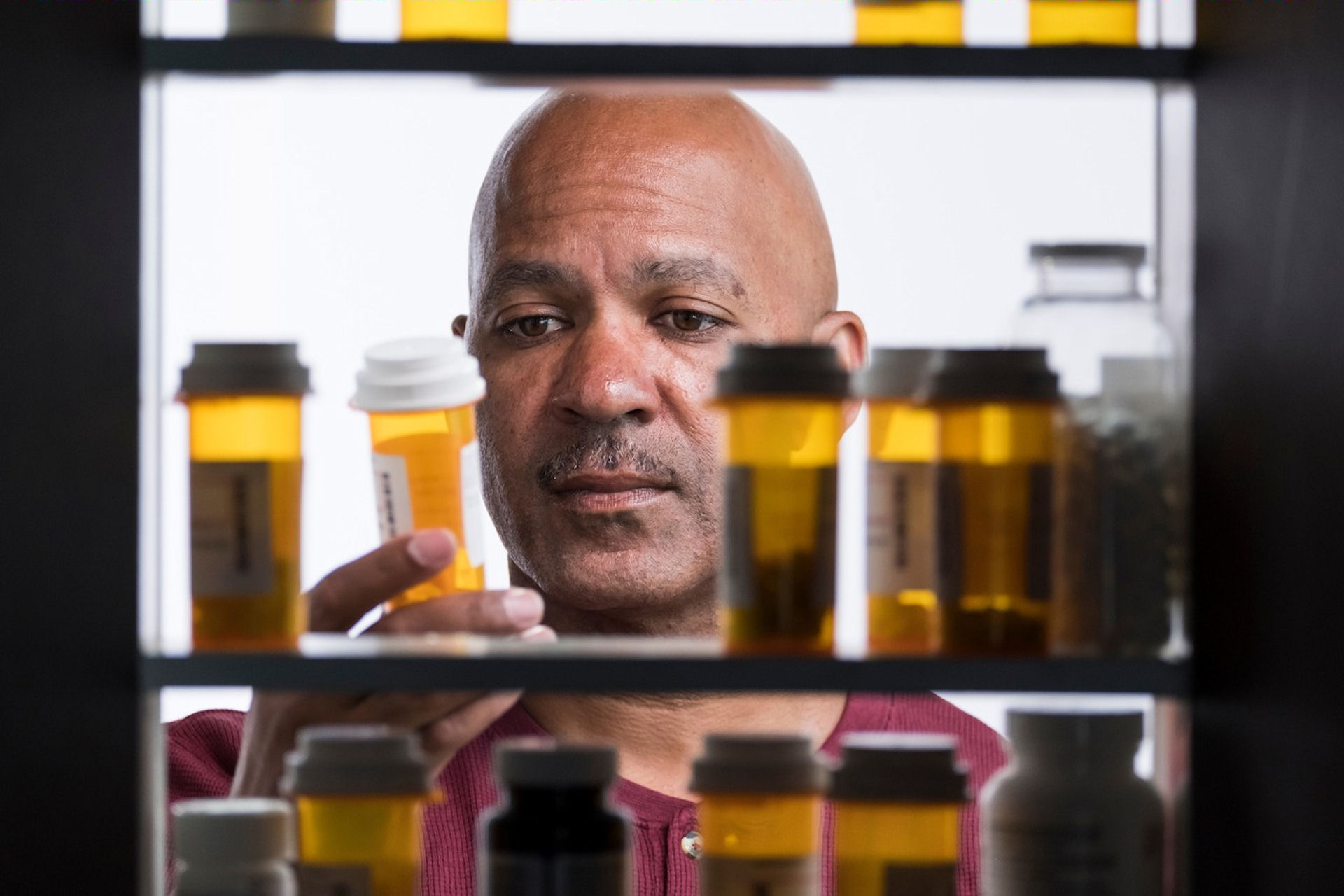 man looking at pill bottles